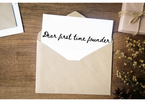 A handwritten note reading "Dear first time founder" pulled halfway out of a kraft paper envelope.
