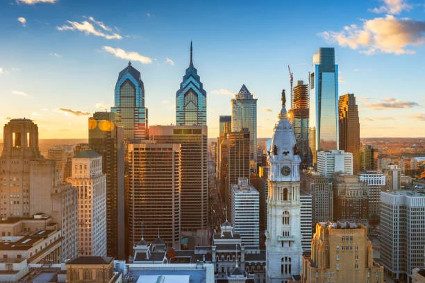 The Philadelphia skyline at sunset, with City Hall's clock tower in the foreground.
